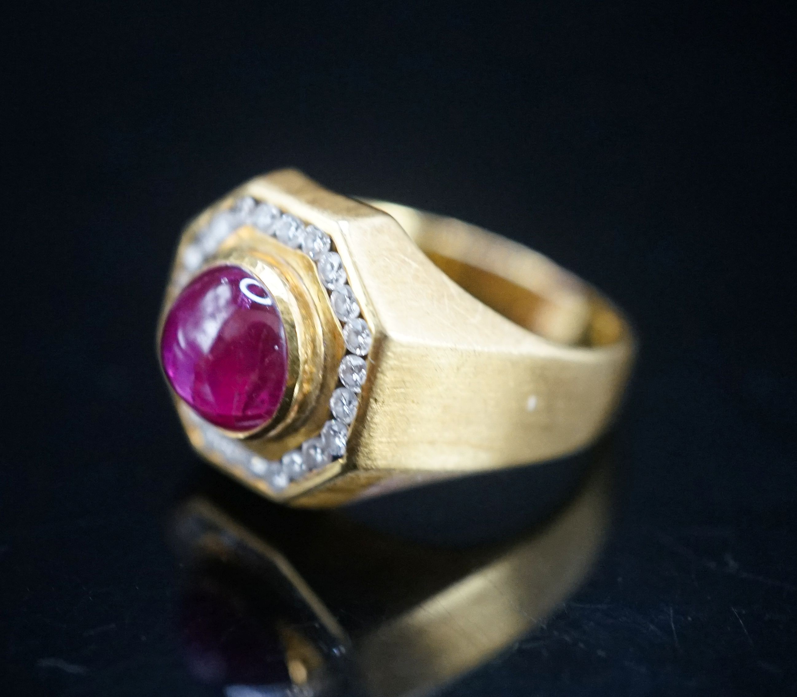A modern continental yellow metal, cabochon ruby and diamond cluster set octagonal dress ring, size Q, gross weight 9.9 grams.